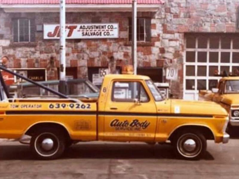 Vintage yellow Metro Auto Body Service tow truck parked on the street