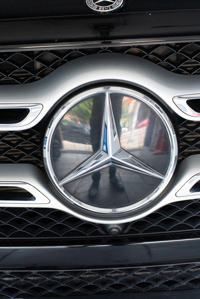 Close-up of a Mercedes-Benz grille badge on a vehicle in for certified collision repair