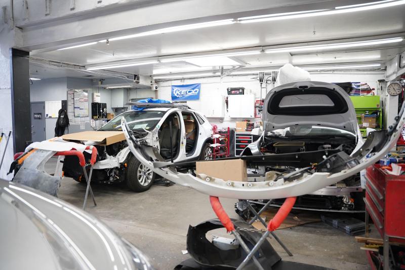 Metro Auto Body parts staging and teardown area with a vehicle in for repair