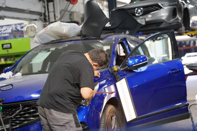 Metro Auto Body technician performing paintless dent repair