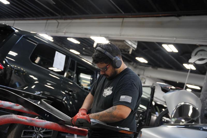 Metro Auto Body technician reassembling trim on a repaired vehicle