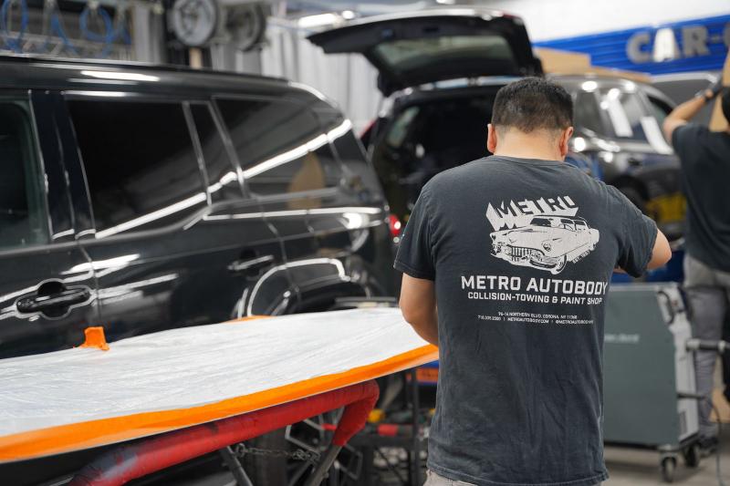 Metro Auto Body technician on the shop floor with vehicles in for repair