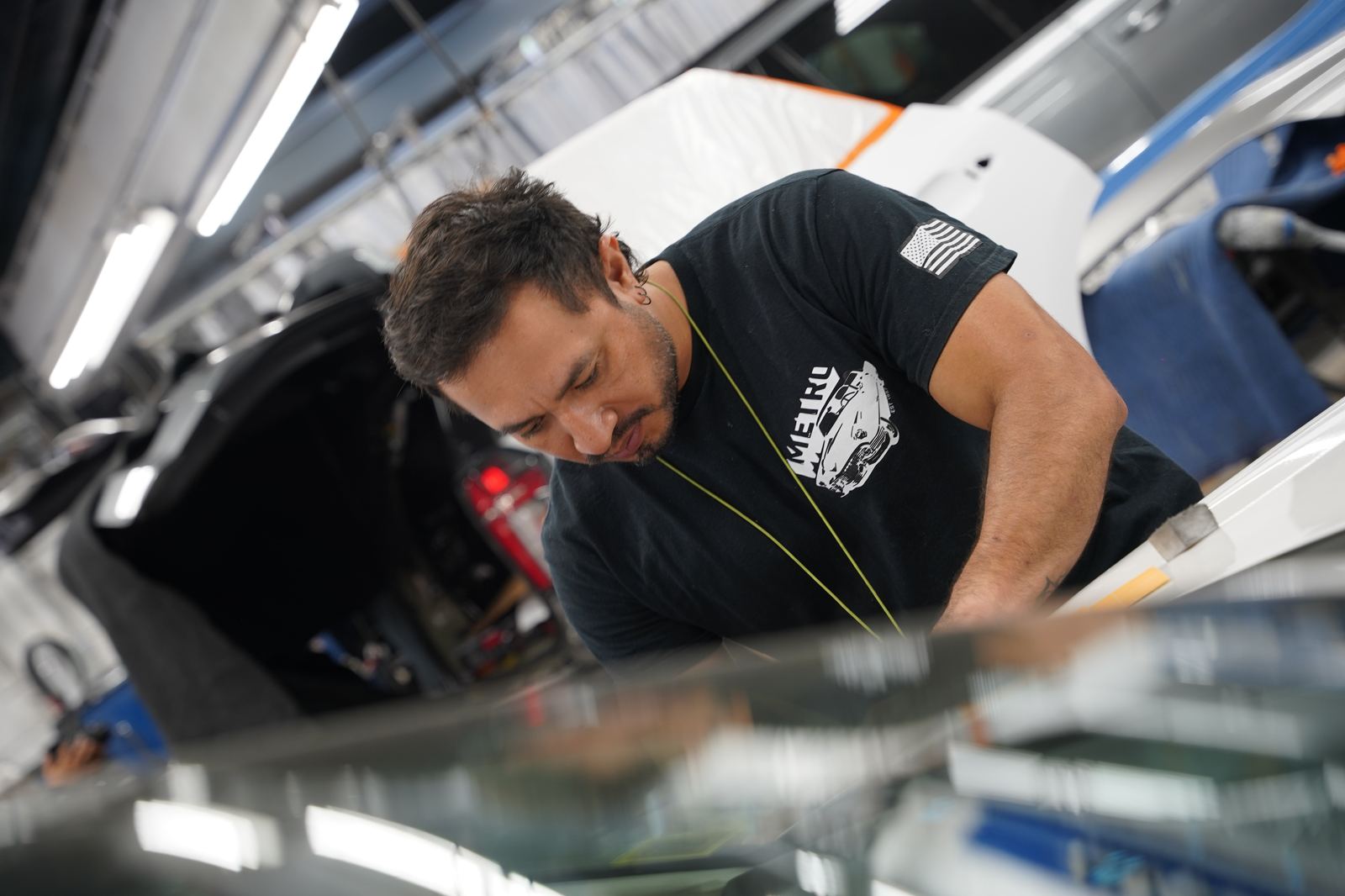 Metro Auto Body technician masking a vehicle for paint