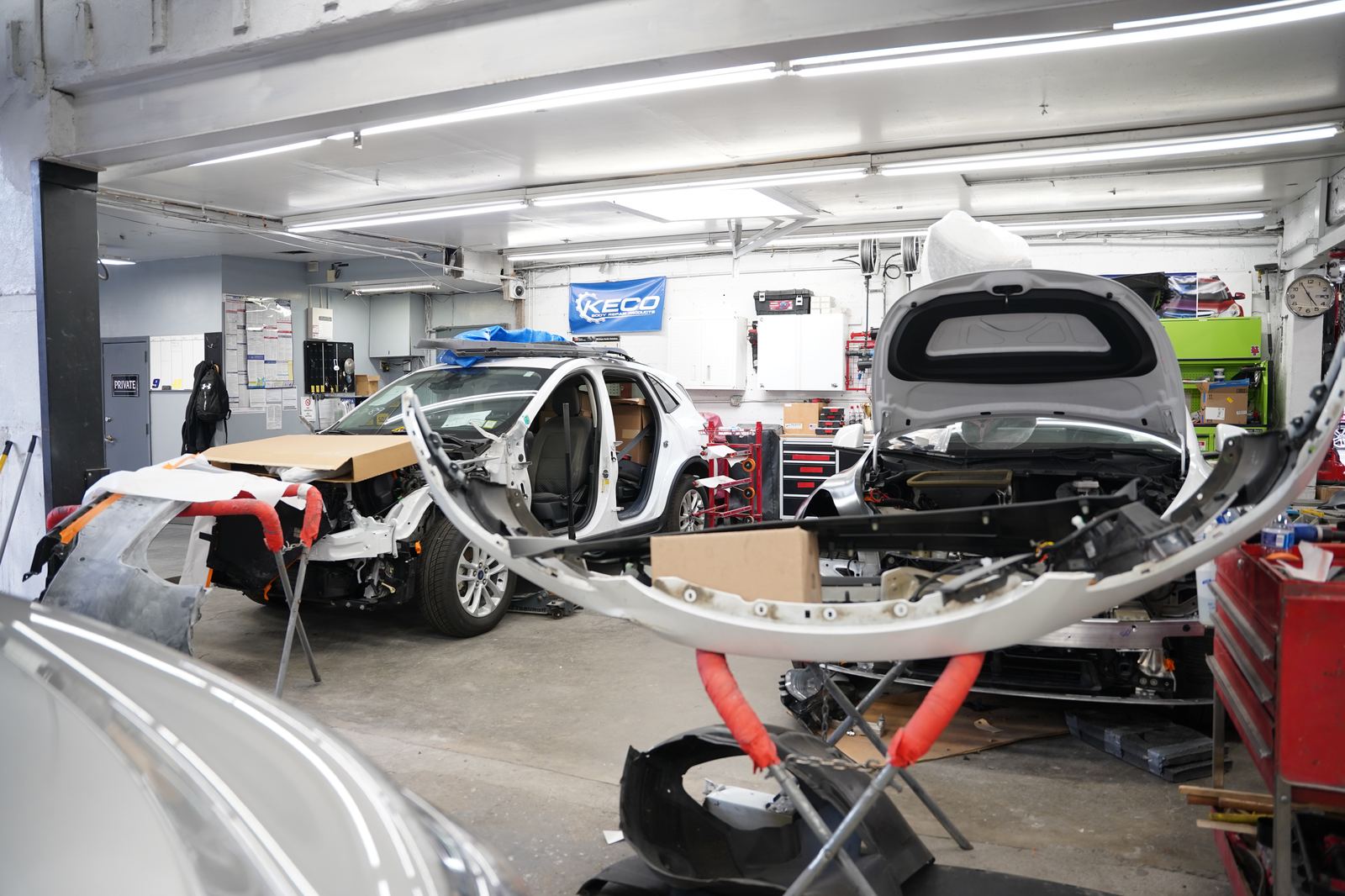 Metro Auto Body parts staging and teardown area with a vehicle in for repair