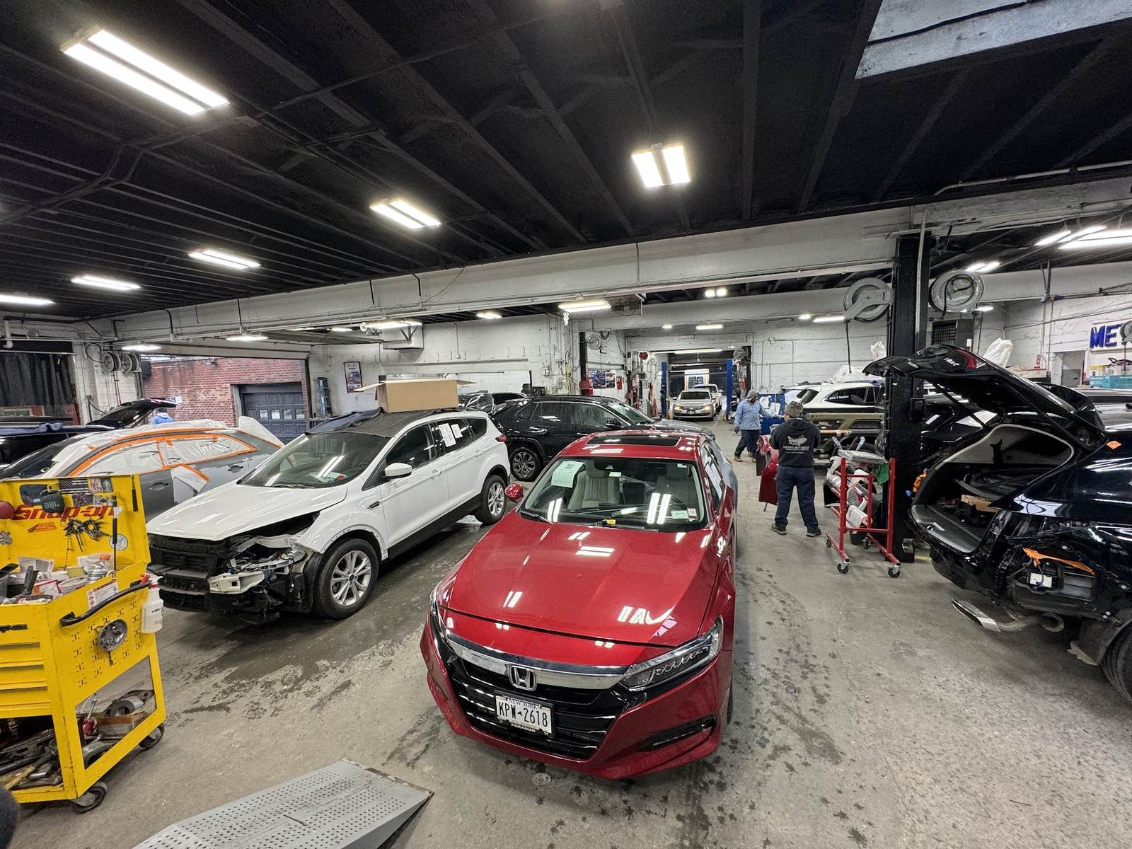Metro Auto Body shop floor in Corona NY with vehicles in for collision repair